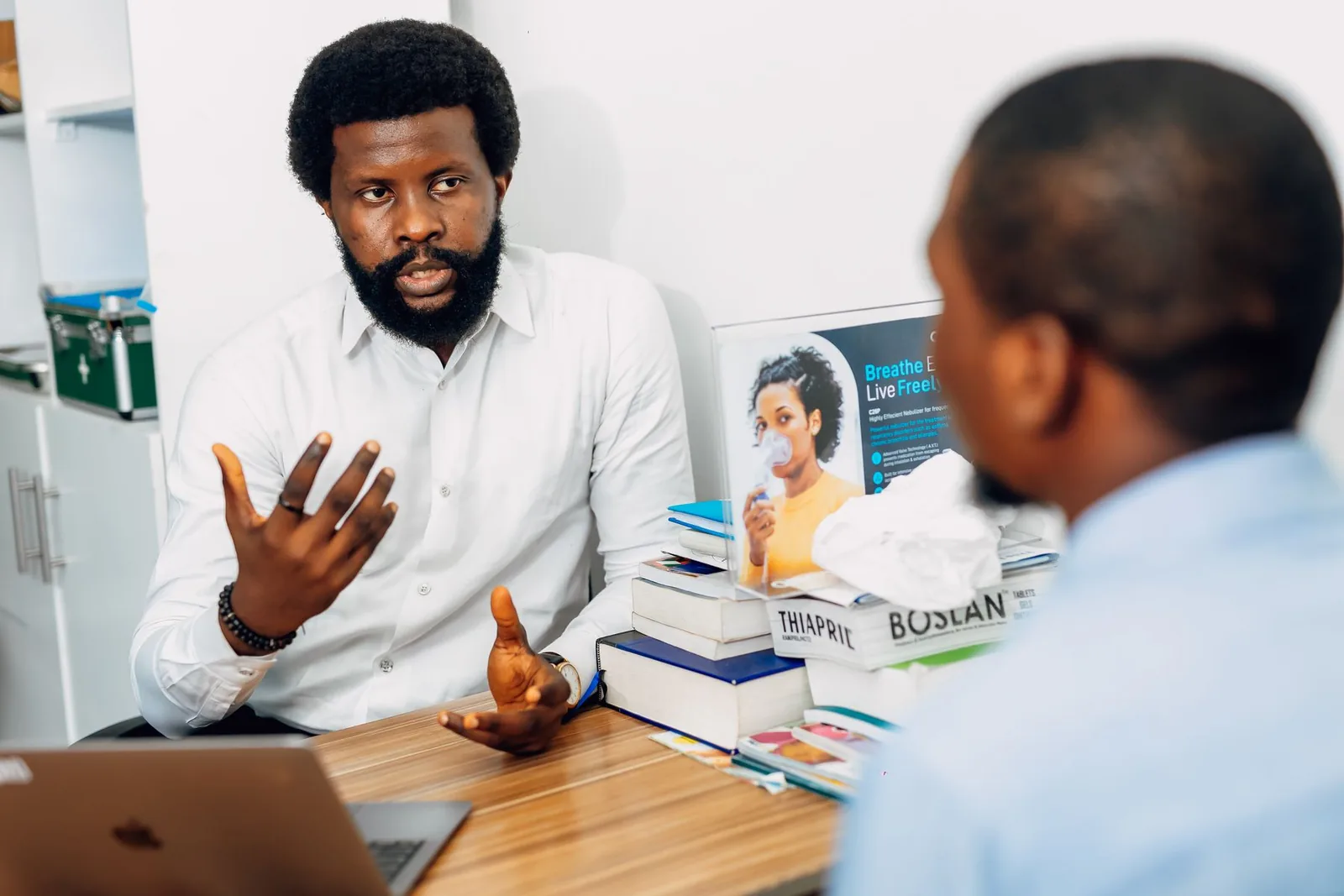 A clinician and patient reviewing information together during a consultation in a Lagos medical office